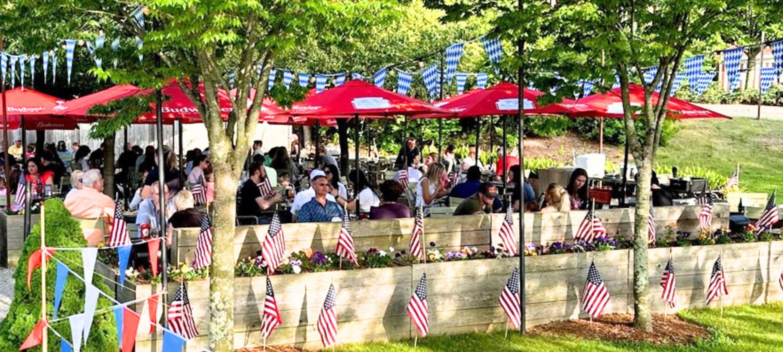 St. Moritz outdoor biergarten packed with diners under the trees